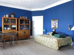 a bedroom with blue walls and a bed and a table at ApartmentInCopenhagen Apartment 1150 in Copenhagen