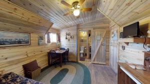 a wooden cabin with a table and a tv at Canyonlands Barn Cabin with Loft, Full Kitchen, Dining Area for Large Groups in Verdure