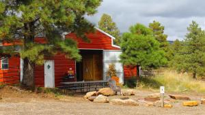a red house with a bench in front of it at Canyonlands Barn Cabin with Loft, Full Kitchen, Dining Area for Large Groups in Verdure