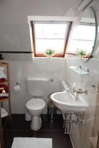 a white bathroom with a sink and a toilet at Ferienwohnung-bei-Familie-Kuehl in Fehmarn