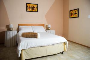 una camera da letto con un letto grande con lenzuola bianche di Khoinonia Guesthouse a Port Nolloth