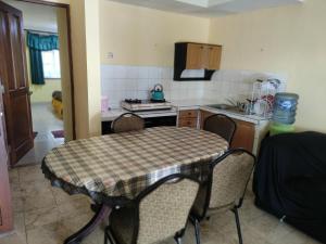 eine Küche mit einem Tisch und Stühlen im Zimmer in der Unterkunft CONDOMINIUM LIPPO CARITA, Lantai Dasar - OFFICIAL in Carita