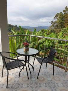 a table and two chairs on a balcony at DOI TUNG Anisa Homestay in Chiang Rai