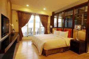 una camera con un grande letto e una televisione di Golden Bay Holiday Inn a Kenting