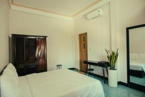a bedroom with a white bed and a desk at HOUSE OF LÝ in Hue