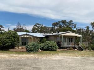 a house with two birds perched on top of it at Big Fella Wines & Accommodation in Stanthorpe