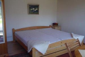 ein Schlafzimmer mit einem Bett mit einem Holzrahmen in der Unterkunft Lütjens Bienenhaus in Ulsnis