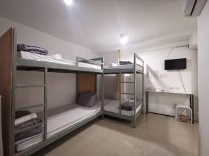 a room with three bunk beds and a television at Studio 41 Salaya-Sai4 in Nakhon Pathom
