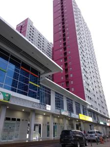 twee hoge gebouwen met auto's geparkeerd voor hen bij Apartment comfy 2 BR Scarlet in Jakarta