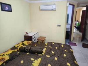 ein Schlafzimmer mit einem Bett mit einer braunen und gelben Decke in der Unterkunft CONDOMINIUM LIPPO CARITA, Lantai Dasar - OFFICIAL in Carita