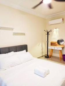 a bedroom with a white bed and a desk at Lotus Desaru G510 by JSS in Bandar Penawar