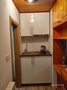 uma cozinha com armários brancos e um lavatório em Jahorina apartman Košuta D5 em Jahorina