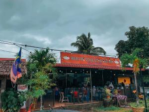 a restaurant with tables and chairs in front of it at Arni Homestay - Geliga in Cukai