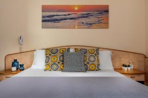 1 dormitorio con 1 cama con almohadas y una pintura en la pared en Hotel Eliseo Riccione, en Riccione