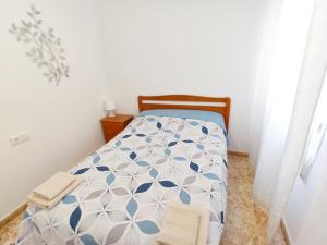 una camera con un letto e un piumone blu e bianco di Beautiful flat with sea view and sound of the surf a Santa Pola