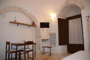 Habitación con mesa, sillas y cama en Trulli don Pietro, en Castellana Grotte