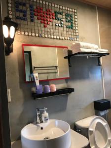 Un baño con lavabo, espejo e inodoro. en 池上5159懷舊民宿 請勿用阿勾達訂房, en Chishang