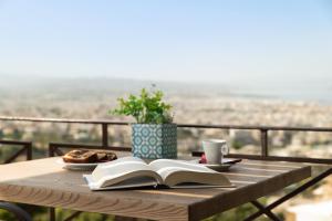 einen Tisch mit einem offenen Buch und einer Tasse Kaffee in der Unterkunft Royal Sun in Chania