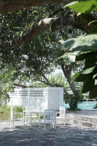 a group of white tables and chairs under a tree at Sevilla Resort Magelang in Magelang