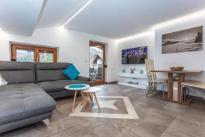 sala de estar con sofá y mesa en Ferienwohnung Steinplatte en Waidring