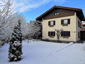 a house with a christmas tree in the snow at Ferienwohnung Werner in Saalfelden am Steinernen Meer