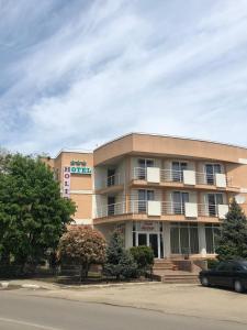 a building with a car parked in front of it at Hotel Holiday in Eforie Nord