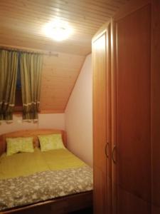 a small bedroom with a bed and a cabinet at Apartment Korošec Matej in Bohinj