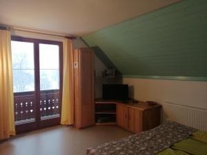 a bedroom with a bed and a television and a window at Apartment Korošec Matej in Bohinj