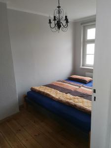 een slaapkamer met een bed en een kroonluchter bij Ferienhaus Elstal in Wustermark