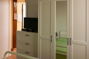 a room with a closet with a television and a bedroom at La casa de Rocche in Cupra Marittima