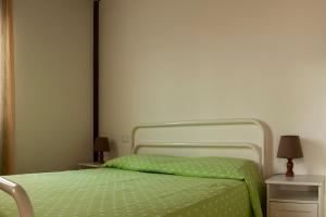 a bed with a green comforter in a bedroom at La casa de Rocche in Cupra Marittima