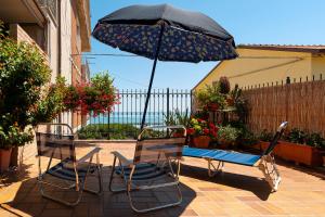 two chairs and an umbrella on a patio at La casa de Rocche in Cupra Marittima