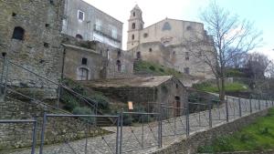 ein altes Steingebäude mit einer Treppe und einem Turm in der Unterkunft La casa del Belvedere in Grassano