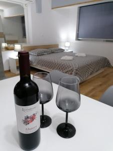 eine Flasche Wein und zwei Weingläser auf dem Tisch in der Unterkunft IOANNOU COURT - Natural Oak STUDIO in Paphos City