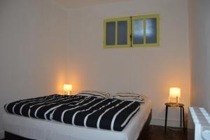 LuzyにあるPetit sejour aux portes du Morvanのベッドルーム1室(白黒のベッド1台、ランプ2つ付)