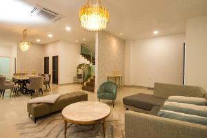 un soggiorno con divani e una sala da pranzo di L.O.V.E Suite a Batu Pahat