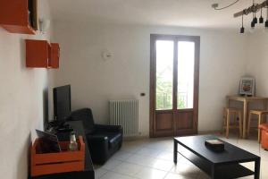 ein Wohnzimmer mit einem Sofa, einem Tisch und einer Tür in der Unterkunft Casa nel bosco, Appennino Tosco Emiliano in Camugnano