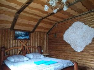 マイコリチンにあるБерлога 2の木製の部屋にベッド1台が備わるベッドルーム1室があります。