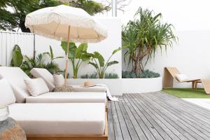 a living room with a white couch and an umbrella at Crystal Pacific Palm Beach in Gold Coast