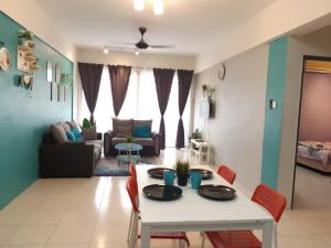 Una sala de estar con una mesa y sillas blancas. en Anis Homestay Bangi, en Bangi