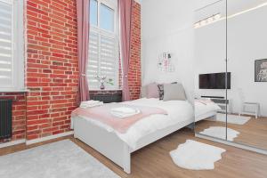 - une chambre avec un lit et un mur en briques dans l'établissement Princess Dream apartment in the heart of Wroclaw, à Wrocław