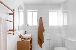 a white bathroom with a sink and a toilet at Crystal Pacific Palm Beach in Gold Coast +19 photos