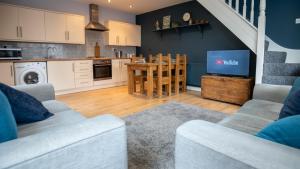 a living room with a kitchen and a dining room at Lovely Coach House with Free Parking in Cardiff