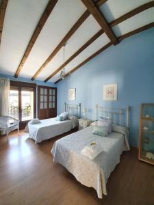 - une chambre avec 2 lits dans une pièce aux murs bleus dans l'établissement Casa Rural Leonor con piscina privada, à Casar de Palomero