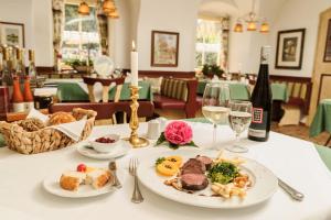 stół z talerzem jedzenia i butelką wina w obiekcie Hotel-Restaurant Kirchenwirt w mieście Weissenkirchen in der Wachau