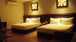 a hotel room with two beds and two windows at Be Boutique Hotel in Kluang