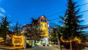 a building with a christmas tree in front of it at Hotel George in Korçë