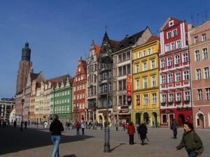 a group of people walking on a street with buildings at Grey Panther Apartment in the Heart of Wroclaw in Wrocław