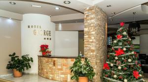choinka świąteczna w holu hotelu w obiekcie Hotel George w mieście Korcza