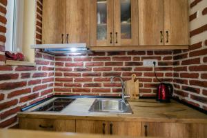 a kitchen with a sink and a brick wall at "34" Apartment in Belgrade